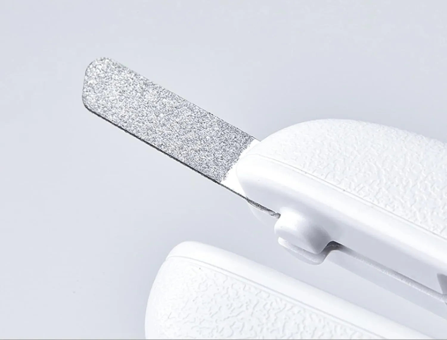 White LED pet nail clippers with transparent guard, triangular blade, and anti-slip handle next to a filing tool.