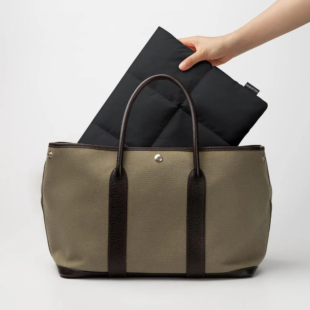 Soft black polyester laptop sleeve for 13-15.6 inch laptops on a table.
