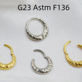 Titanium alloy concave-convex nose ring with carving detail in gold and silver anodised finishes.