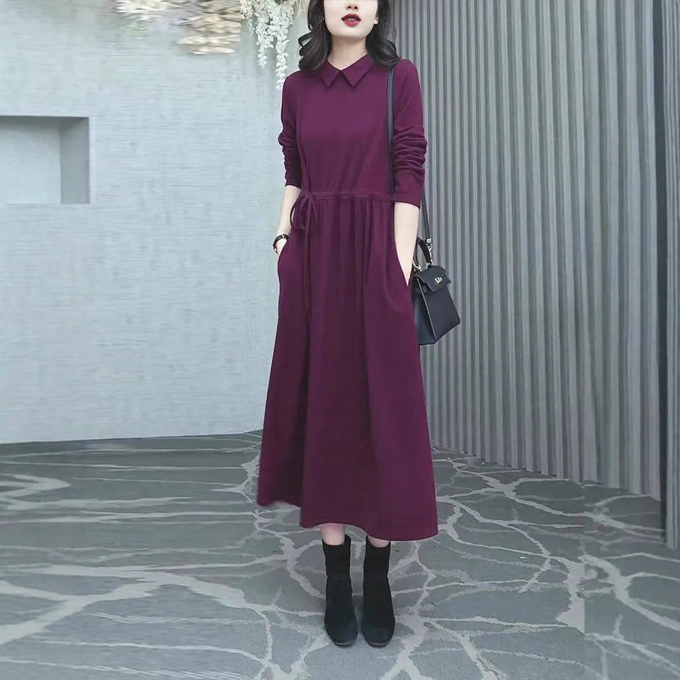 Purplish red women's plus size long sleeve dress with a long skirt, shown on a hanger.