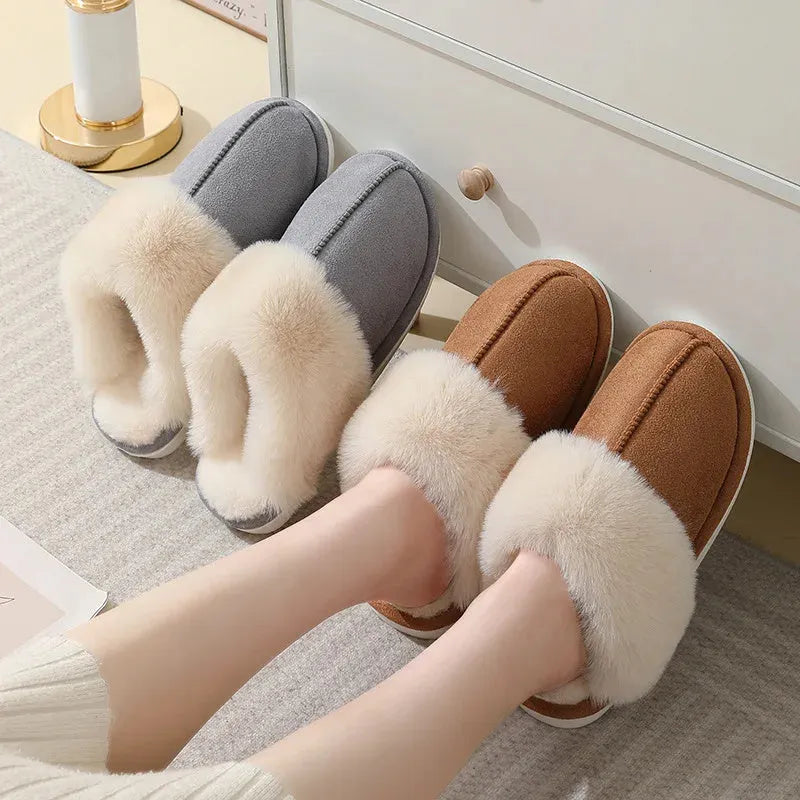 Brown plush indoor slippers with round toe, decorative stitching, and a light-coloured anti-slip sole.