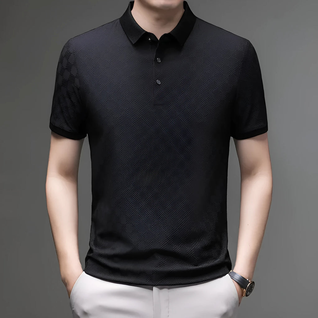 Man wearing a black rhombus patterned short sleeve t-shirt with a side slit detail.