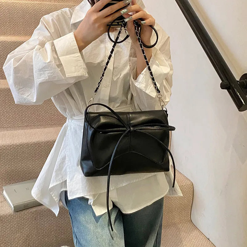 Women's black PU leather crossbody bag with a horizontal square shape and crossbody strap