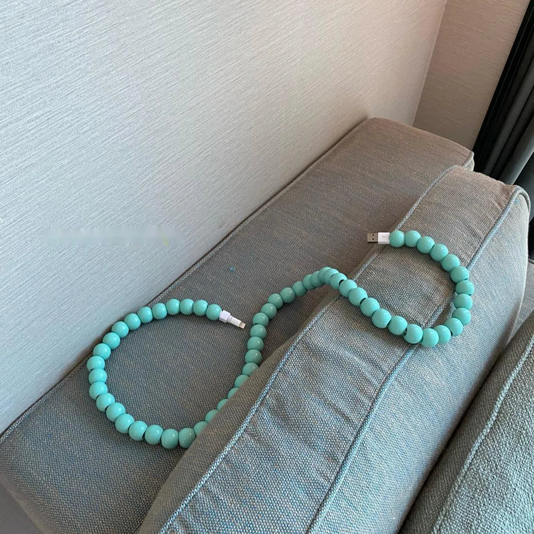 Mint green USB data cable with straight head connector on a white background