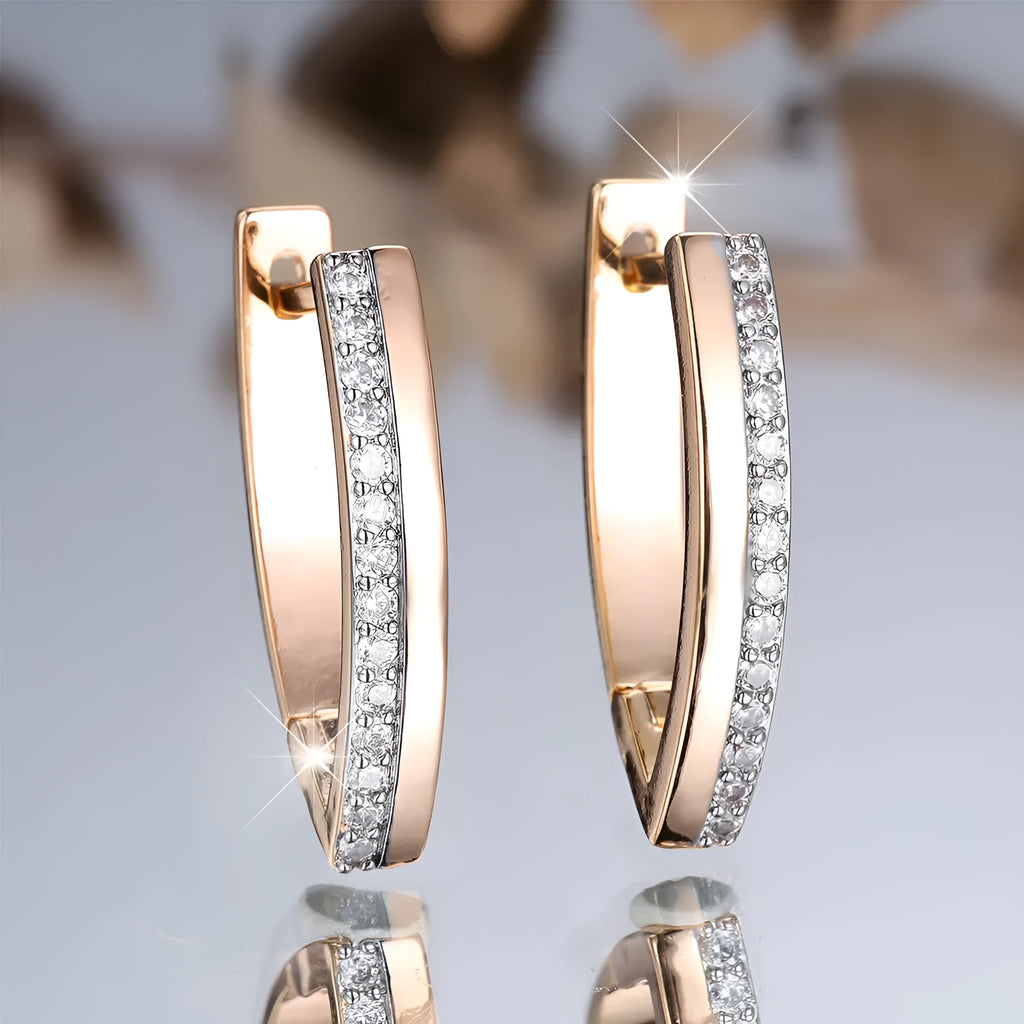 Geometric V-shaped women's earrings in champagne gold with white diamond accents on a copper base.