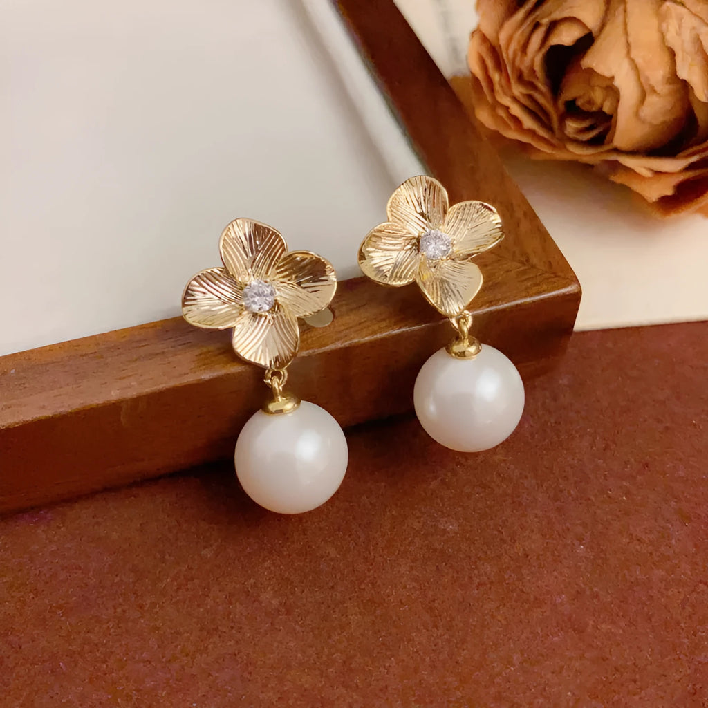 Pair of gold-plated copper earrings with metal petal design and faux pearl accents for women