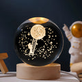 Luminous crystal ball with landing moon design on wooden base, illuminated by LED