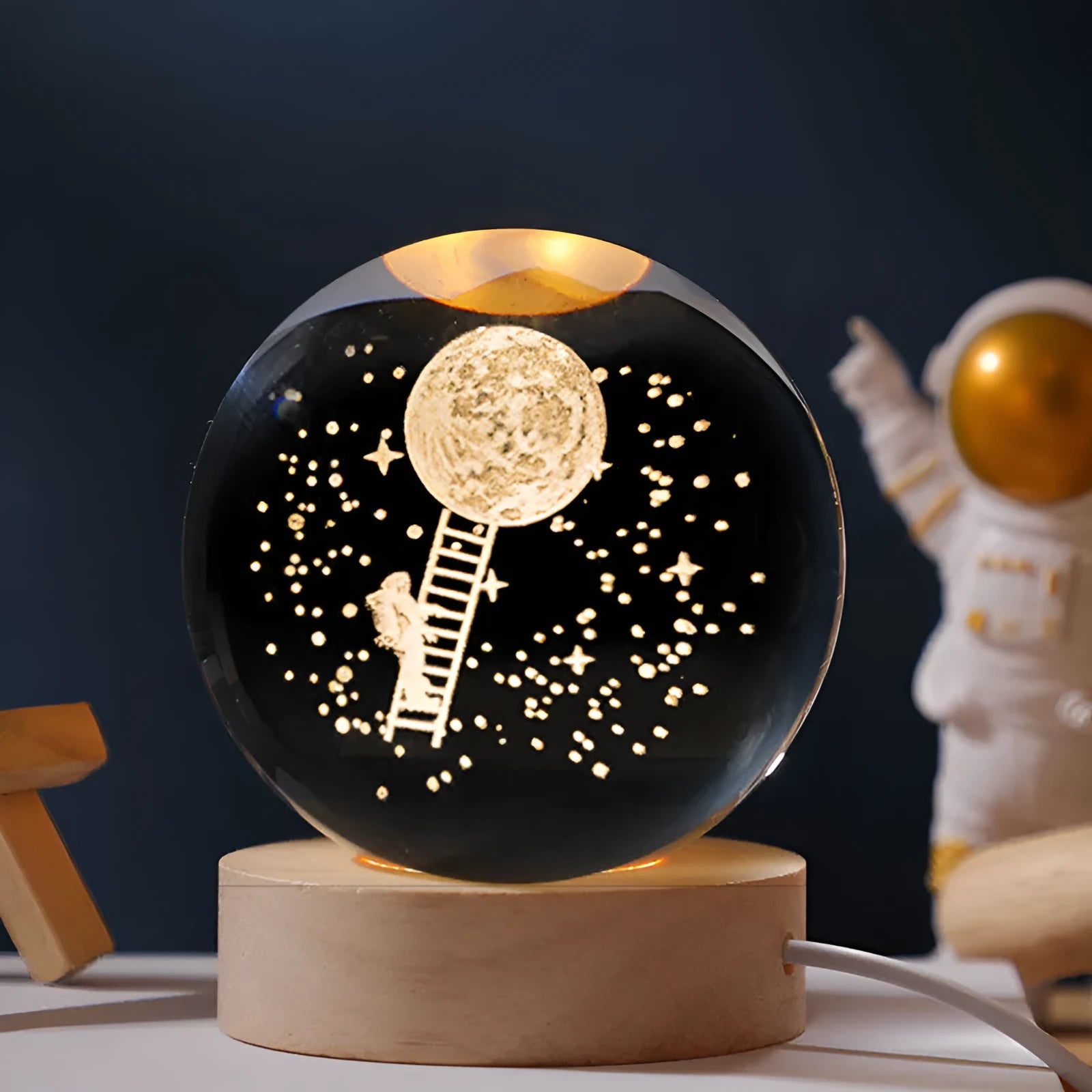Luminous crystal ball with landing moon design on wooden base, illuminated by LED