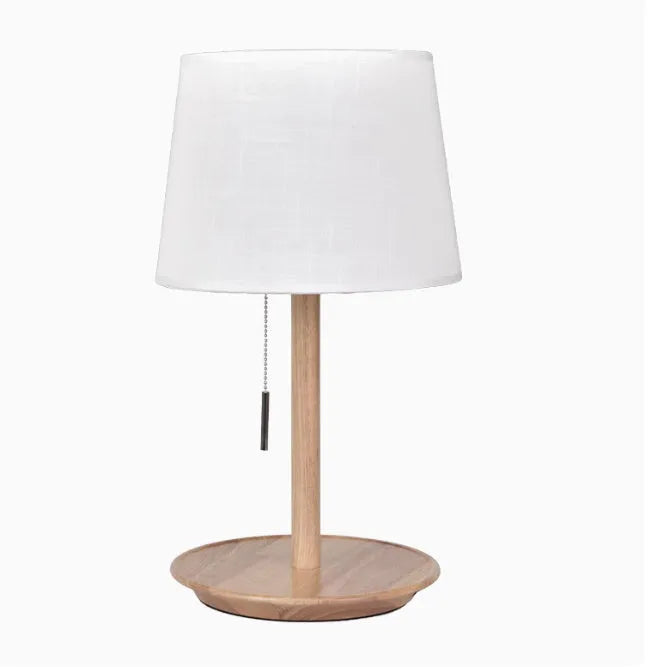 Walnut-coloured solid wood bedside lamp with white cloth shade and cable switch