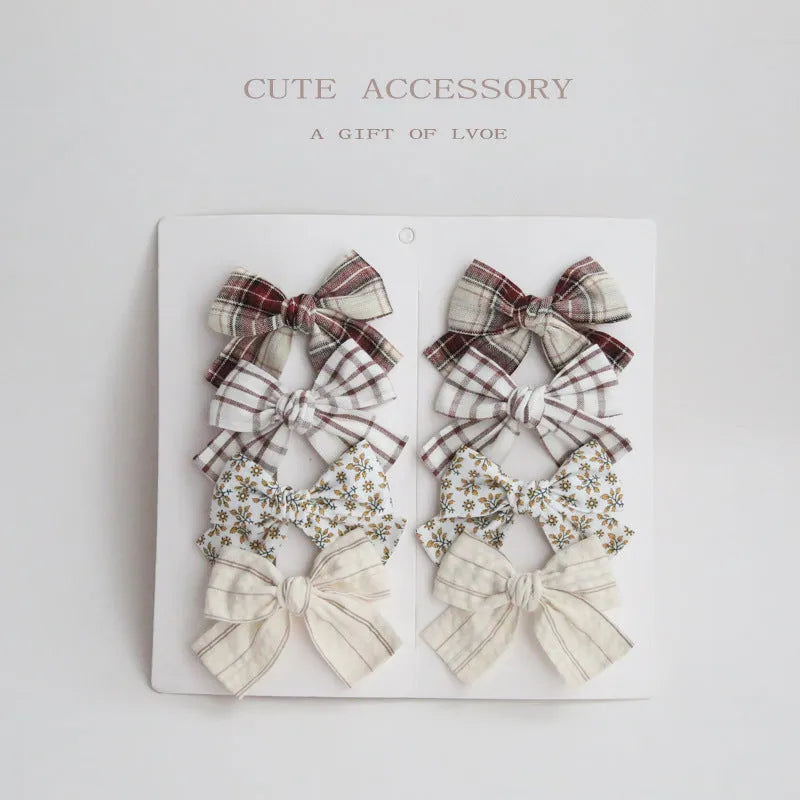 Set of children's fabric hairclips with dovetail bows in eight different colours and patterns.