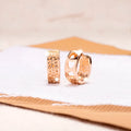 Rose gold heart-shaped women's earrings with three hollowed out sections in a circular design.