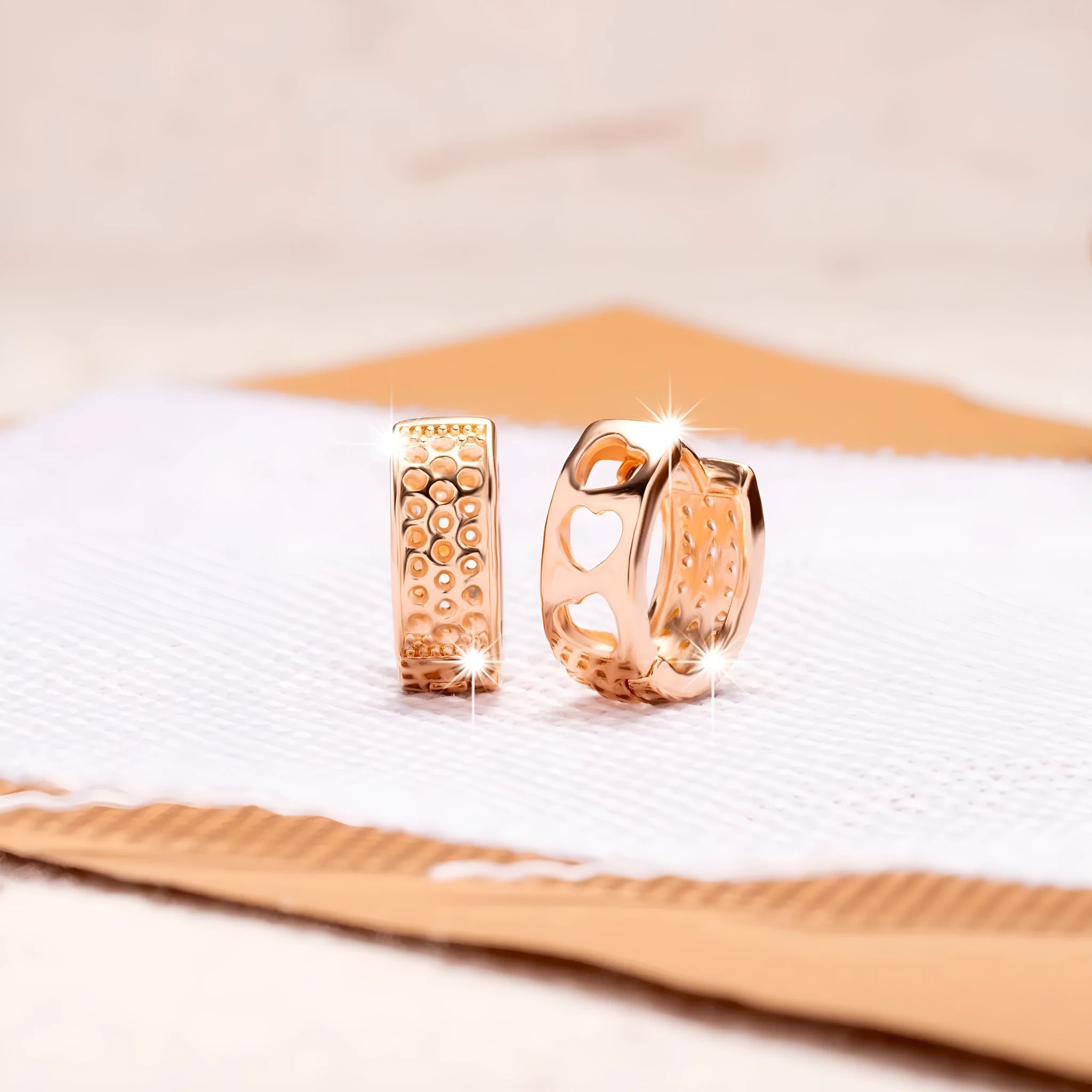 Rose gold heart-shaped women's earrings with three hollowed out sections in a circular design.