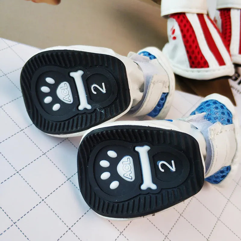 Four blue cloth dog shoes with zipper closures and non-slip soles arranged together