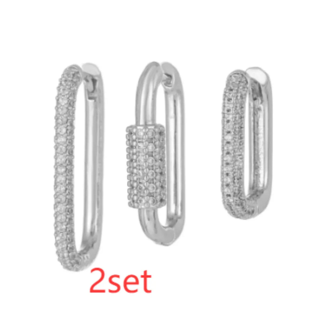 Three geometric ear clips with micro-inlaid zircon stones on copper, showing gold and white gold colour options