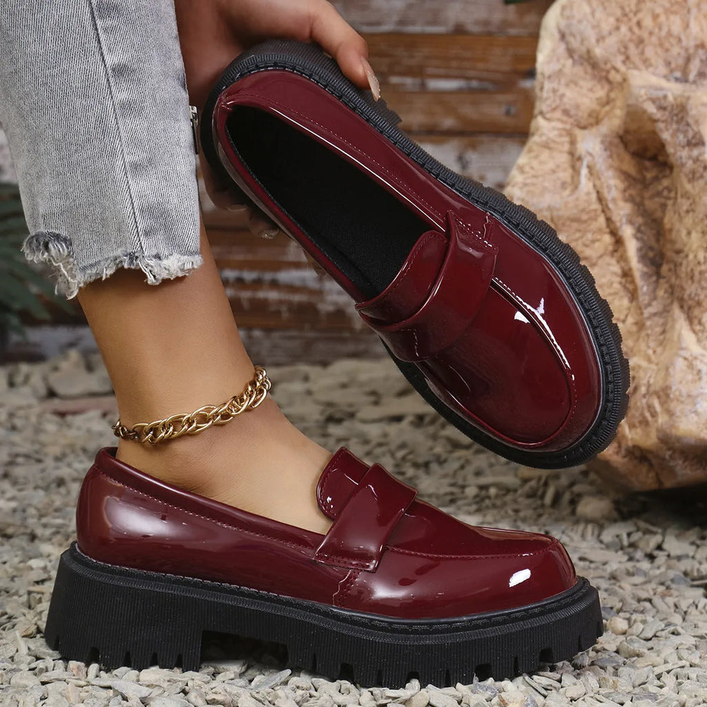 Plus size black slip-on loafers with chunky platform heel on a solid colour background