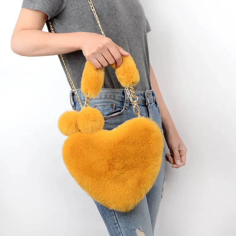 Soft plush heart-shaped women's handbag in a medium size with a removable shoulder strap.