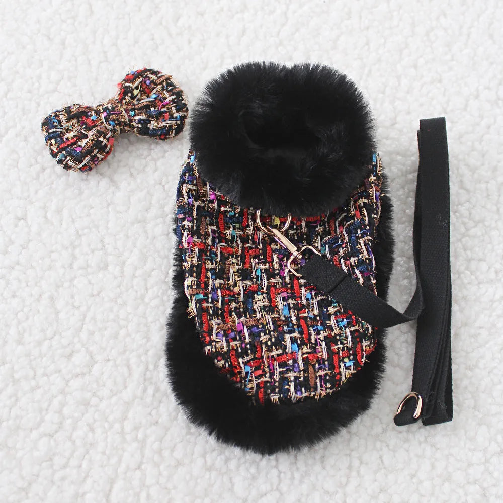 A dog wearing a classic-style cloth chest harness with an attached decorative cloak and integrated hand-holding rope.