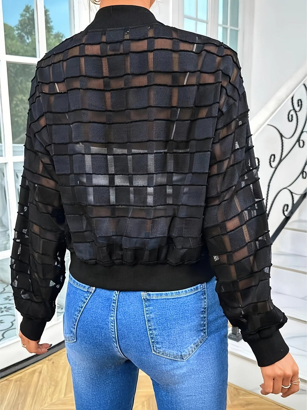 Black women's semi-transparent jacket with geometric pattern and front zipper.