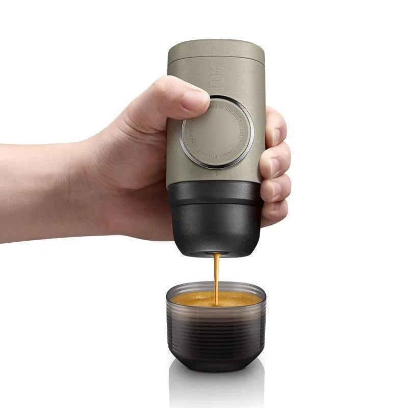 Olive gray manual espresso portable capsule coffee machine with storage bag and accessories on outdoor table