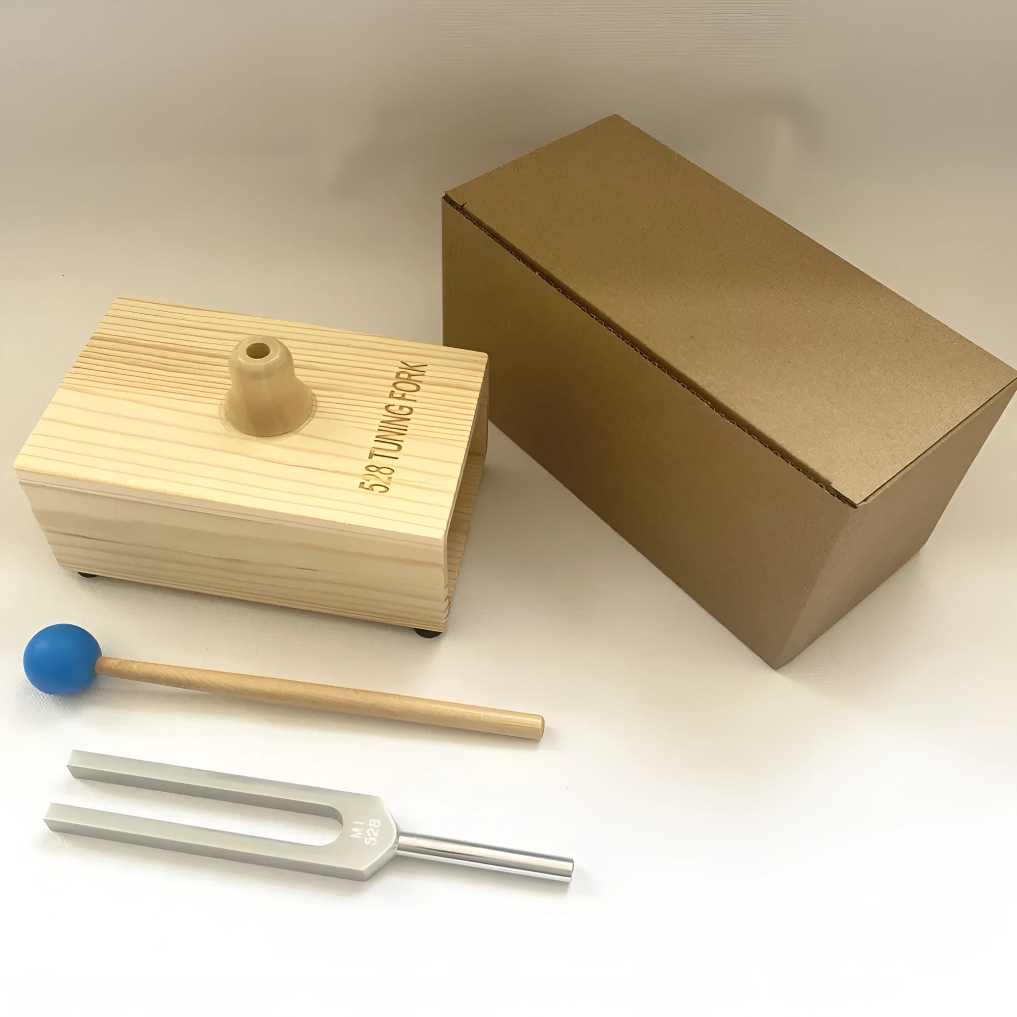 Aluminium alloy 432Hz tuning fork with speaker on kraft paper box background
