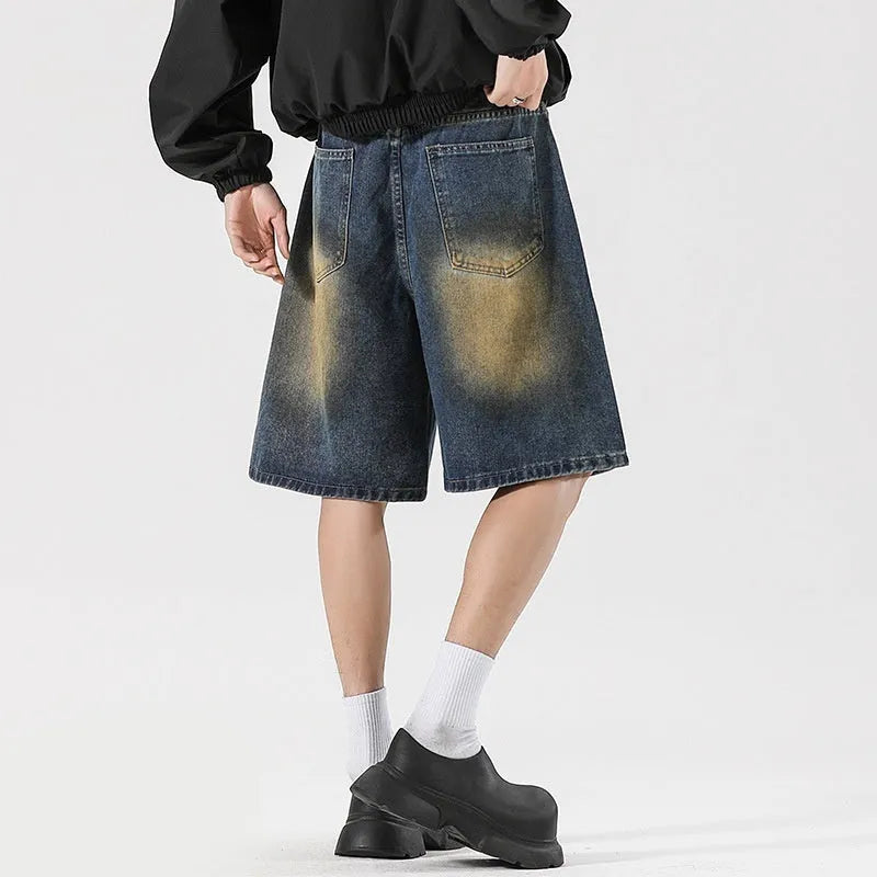 Man wearing retro blue loose fit ripped denim jeans with distressed details.
