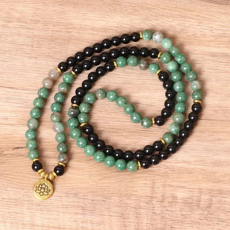 Green and black alloy elastic beaded bracelet on a wrist.
