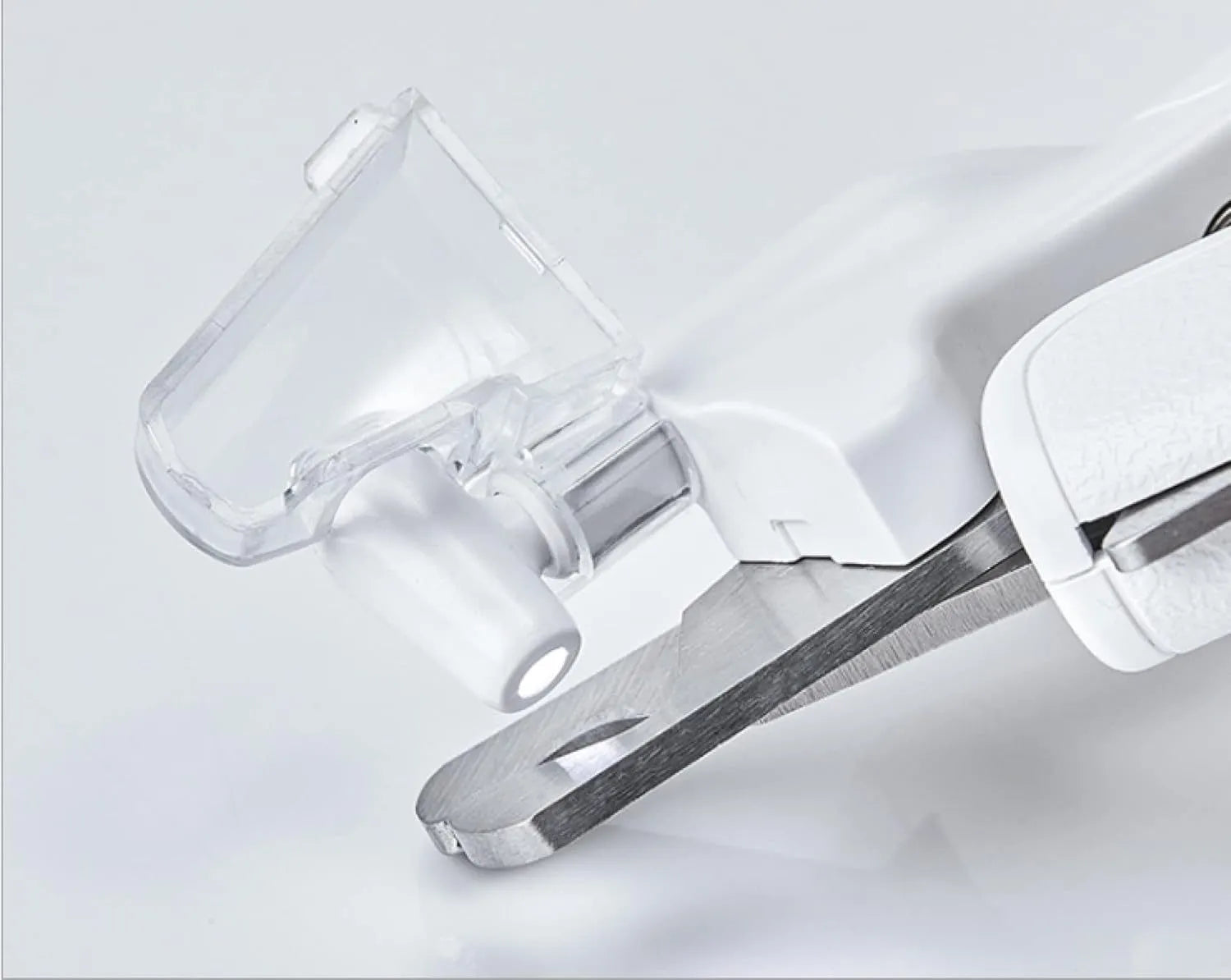 White LED pet nail clippers with transparent guard, triangular blade, and anti-slip handle next to a filing tool.