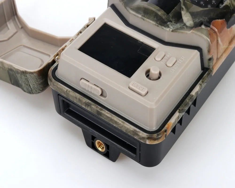 Compact camouflage infrared hunting camera with lens and infrared LEDs visible.