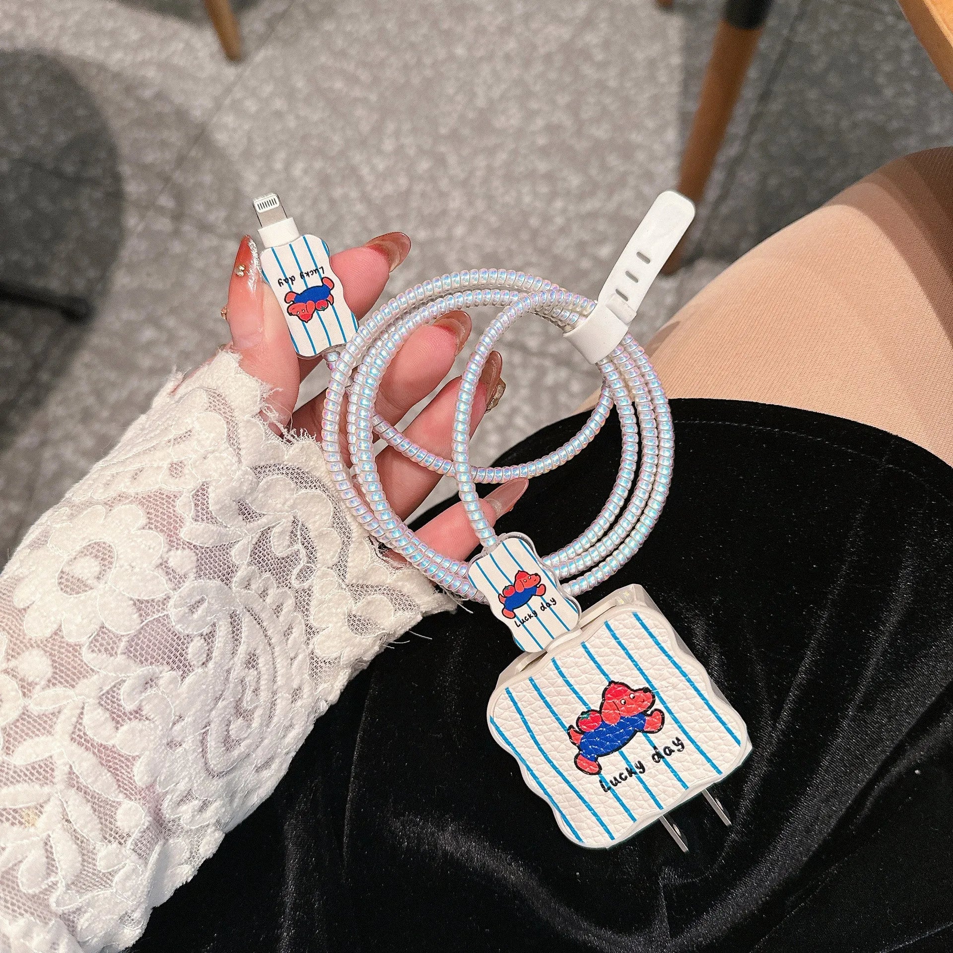 Set of four lambskin adhesive protective sleeves for USB charging cables in cartoon puppy patterns.