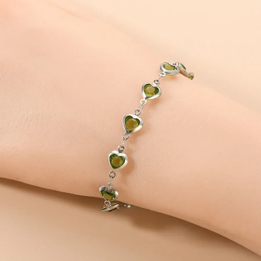 Stainless steel heart-shaped bracelet with electroplated geometric design in various colours like red, blue, and green for unisex wear.