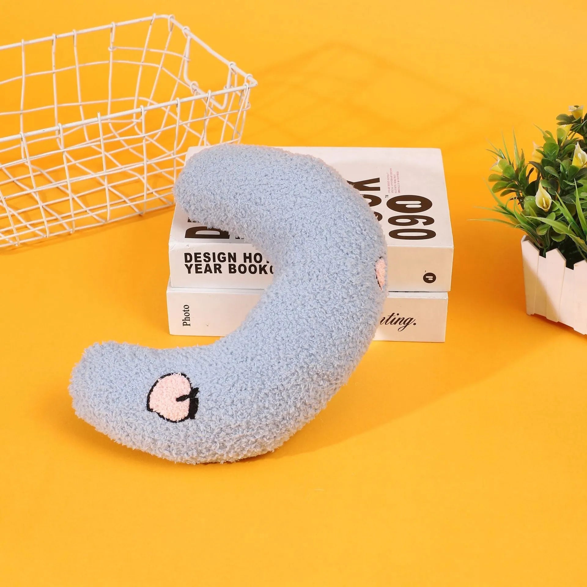 Blue half moon U-shaped cloth pillow for pets in a crate.
