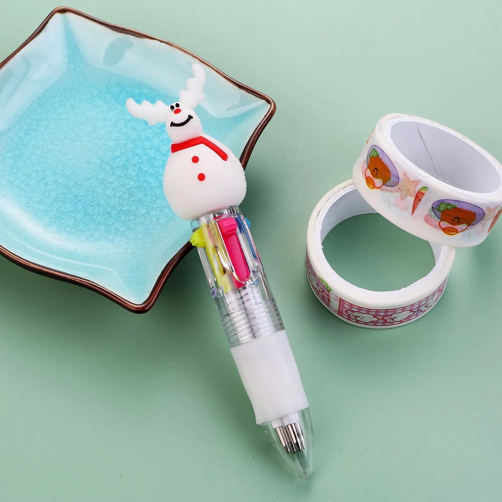 Christmas mini four-colour press-type ballpoint pen showing festive designs, 11cm long.