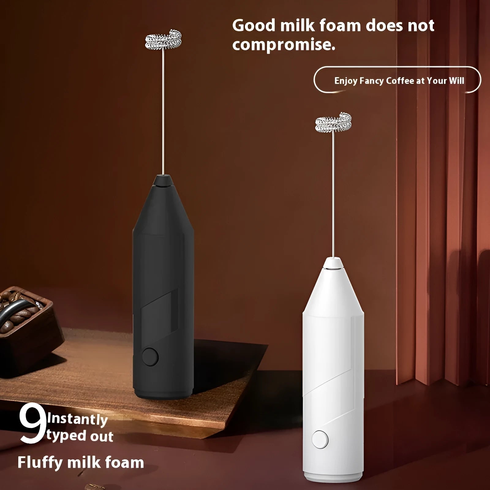 Compact black handheld milk frother with stainless steel whisk on a kitchen counter.