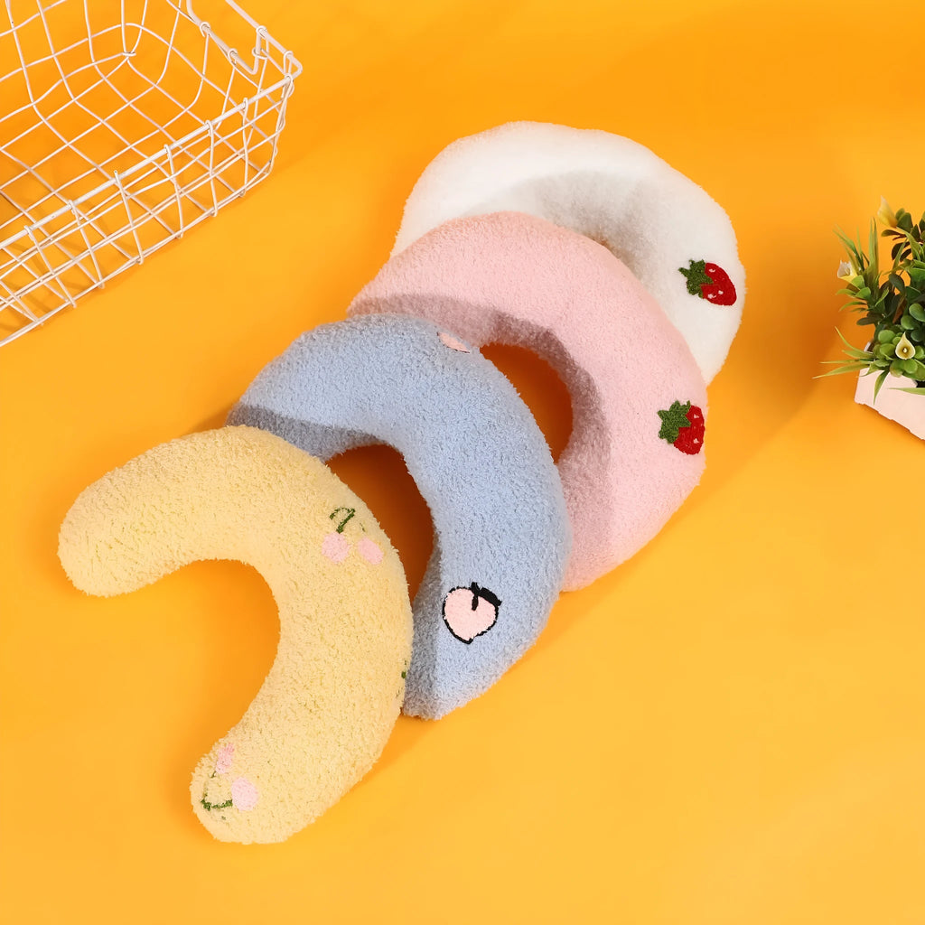Blue half moon U-shaped cloth pillow for pets in a crate.