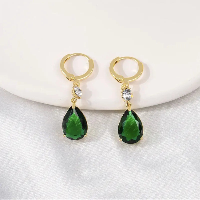 Geometric green teardrop alloy earrings on a plain background