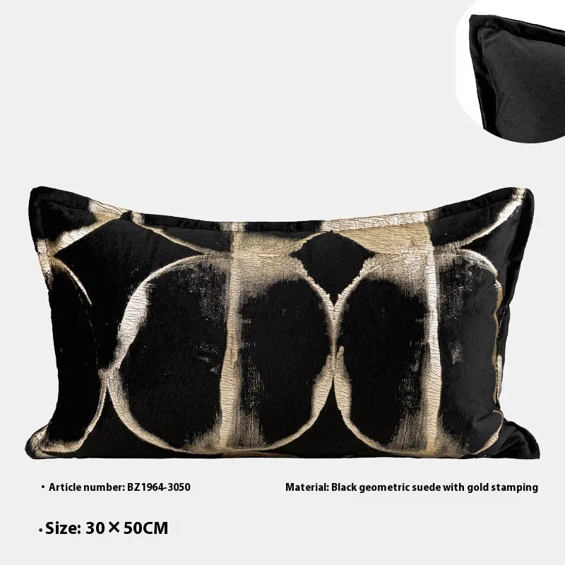 Black and gold abstract print flannel decorative cushion pillow on a sofa.