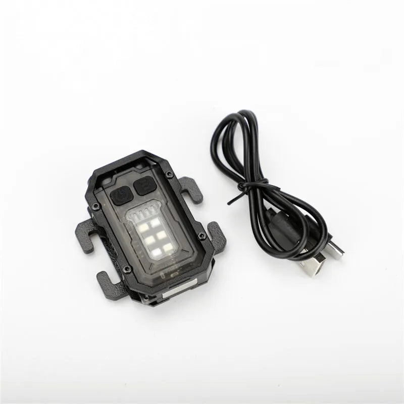 Mini black tactical warning flashlight with USB charging cable for backpack mounting.