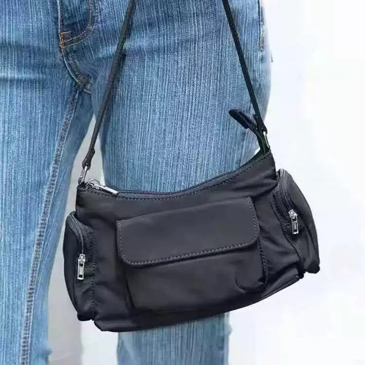 Black lightweight PU women's shoulder bag with two front pockets showing side stitching detail