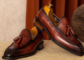 Men's black genuine leather slip-on loafers showing polished finish and rubber sole