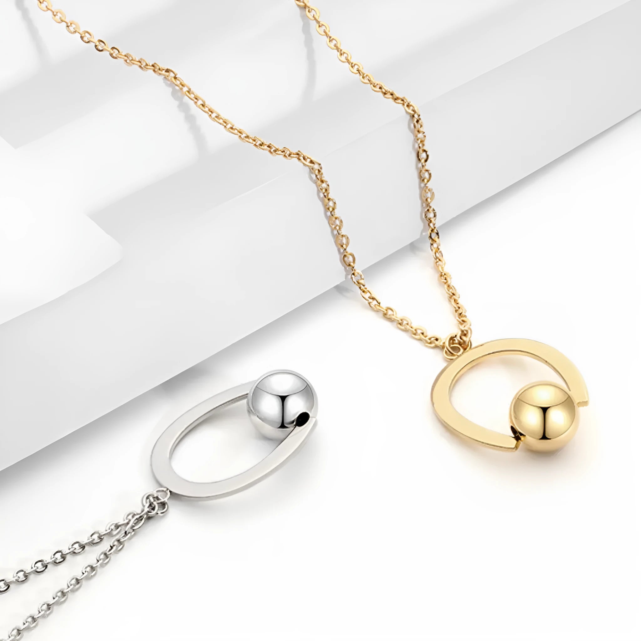 Gold or silver electroplated stainless steel geometric pendant necklace on a cross chain.