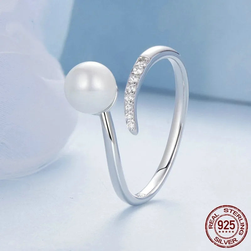 Silver adjustable ring with shell pearls showing open loop design for size adjustment