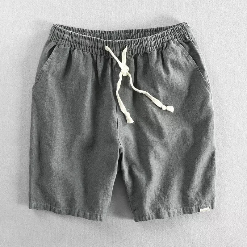 Man wearing loose-fit beige cotton linen casual shorts on a beach