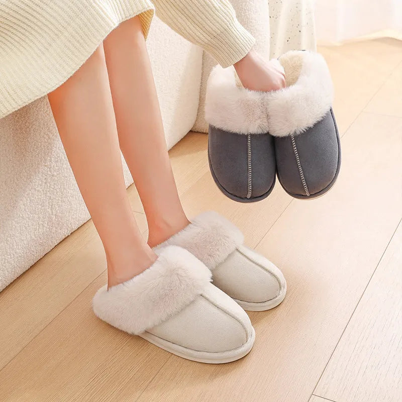 Brown plush indoor slippers with round toe, decorative stitching, and a light-coloured anti-slip sole.