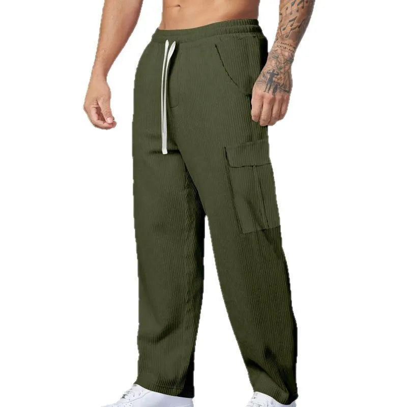 Man wearing loose-fitting navy blue corduroy cargo trousers with a straight leg and drawstring waist.