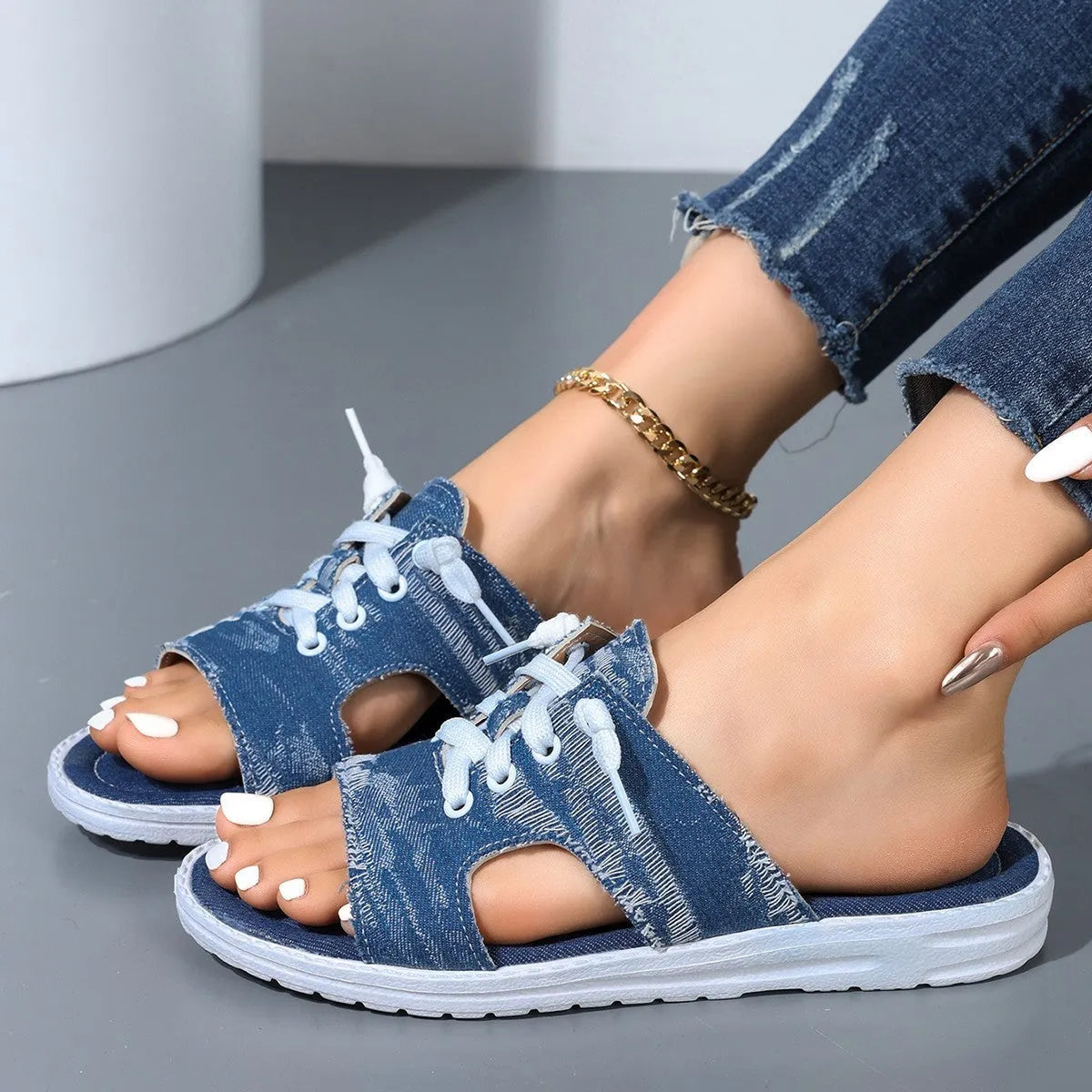 Blue women's flat canvas roman slippers with cloth lining and a rubber sole.
