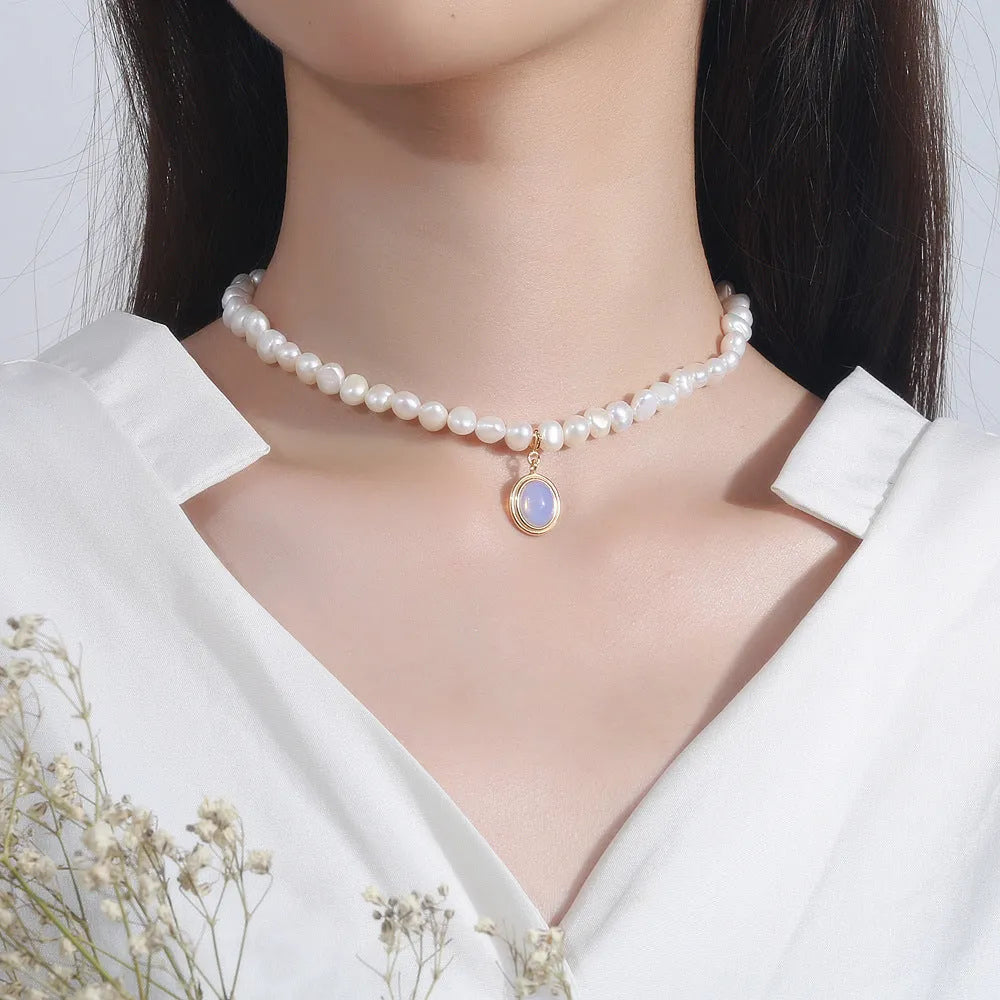 Sterling silver geometric necklace with irregular pearl pendant on adjustable chain.