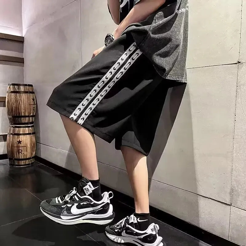 Men's loose-fit grey track pants with an elasticated waist on a neutral background.
