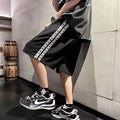 Men's loose-fit grey track pants with an elasticated waist on a neutral background.