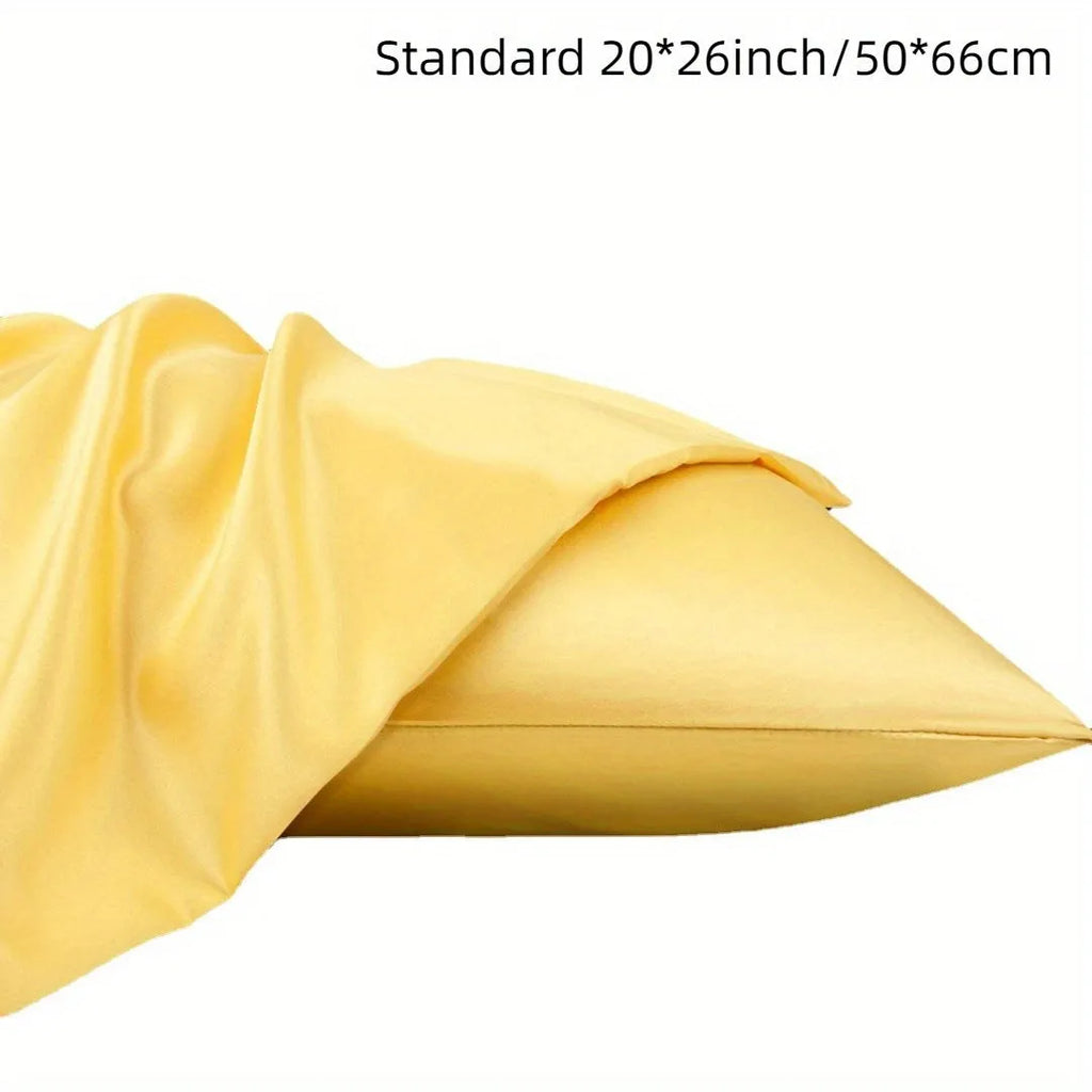 A pair of solid colour satin pillowcases in various shades on a bed.