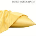 A pair of solid colour satin pillowcases in various shades on a bed.